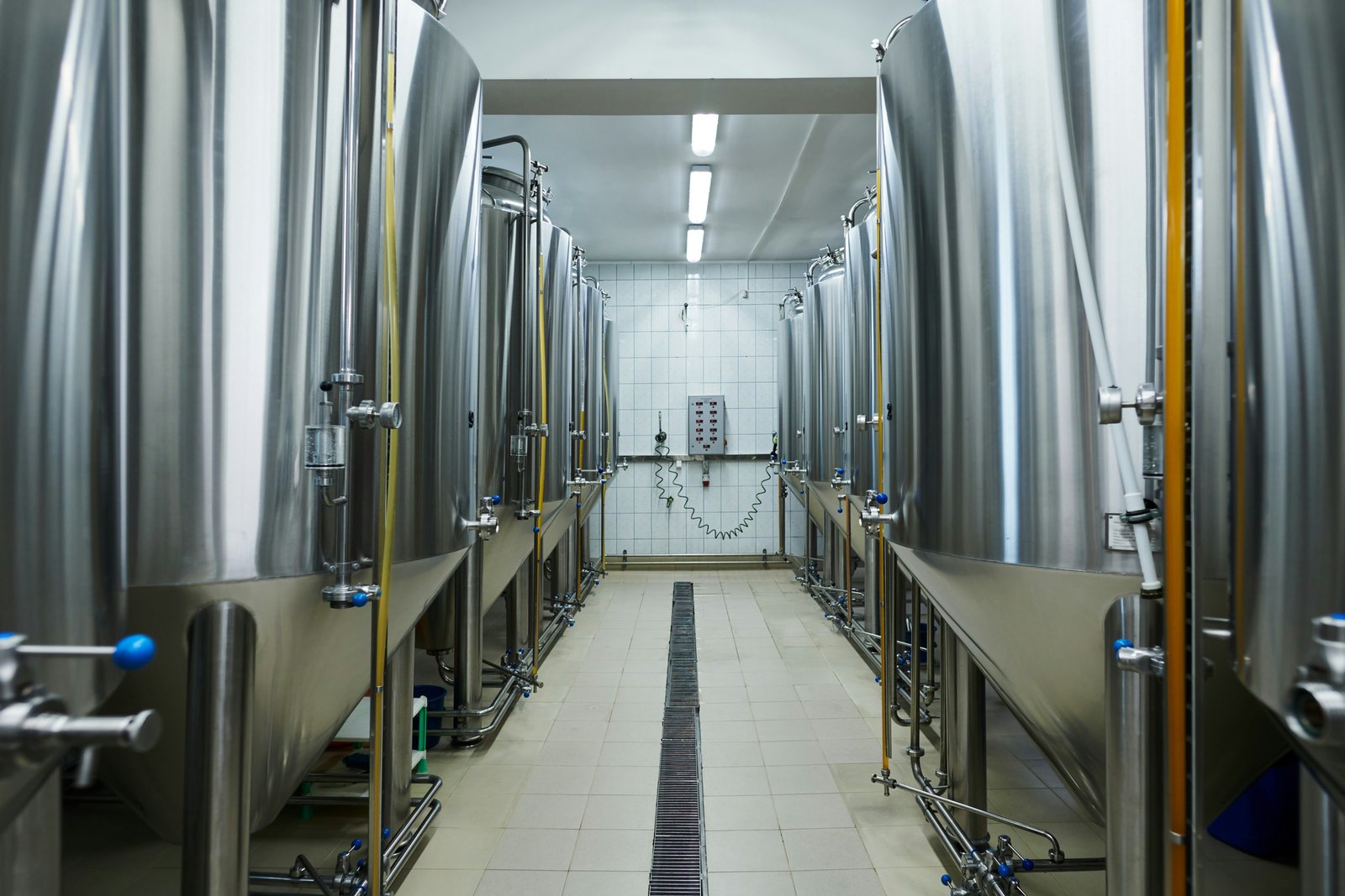 Rows of stainless steel processing tanks in an industrial facility.